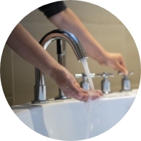 Photo of an owner washing his hands in the bathtub faucet.