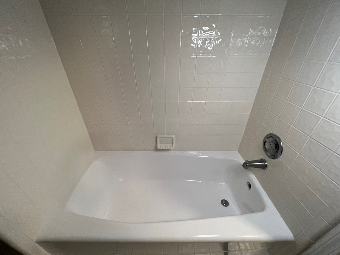 Photo of bathroom with white bathtub and tiles